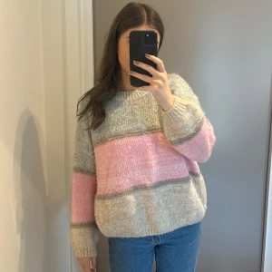 Stickad trlja - En supermysig tjock stickad tröja o rosa, beige o grå! Använd 2ggr så i nyskick! Väldigt fin modell och bra kvalitet. Är i onesize så beror på önskad passform. Jag är storlek S för referens