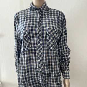 Skjorta arbetsskjorta rutig  - Fläck enligt bild och bara en knapp i ena ärmen. I övrigt inget att anmärka på.