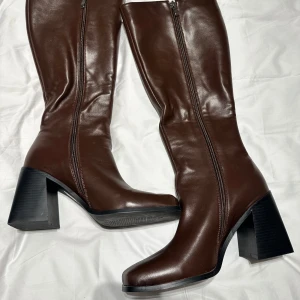 Boots med blockklack - Ett par skitsnygga högklackade boots i en brun färg😻 Köpta på Zalando (De är slutsålda där nu) och är märket RAID. Klackhöjden är 9 cm och storleken är 40. Är använda en gång då de är lite för tighta för mig. Nypris är 800, mindre än 1 år gamla! 