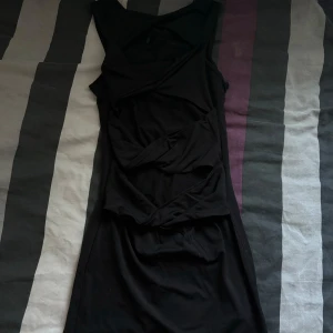 Svart klänning från PrettyLittleThing - Säljer en elegant svart klänning från PrettyLittleThing. Den är ärmlös och har en tight passform som framhäver figuren. Perfekt för en festkväll. Klänningen är i nyskick och redo att bäras av någon som vill känna sig extra.