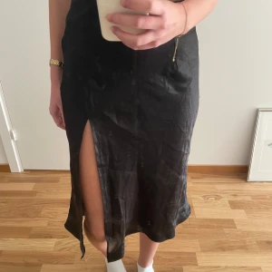Svart silkeskjol med hög slitt - Snygg kjol med hög slitt! 🦋Har någon enstaka tråd lös och lite smått nopprigt material på enstaka ställe