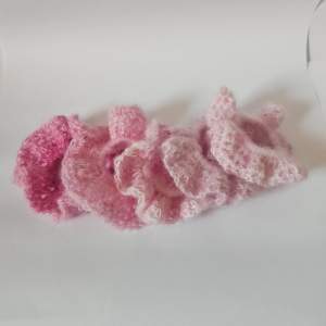 supergulliga rosa virkade scrunchies. De är fluffiga och perfekta för att ge en söt touch till din frisyr. Färgerna varierar från ljusrosa till mörkrosa, vilket gör dem perfekta för alla tillfällen. Säljsstyckvis 