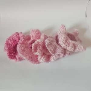Rosa stickade scrunchies - supergulliga rosa virkade scrunchies. De är fluffiga och perfekta för att ge en söt touch till din frisyr. Färgerna varierar från ljusrosa till mörkrosa, vilket gör dem perfekta för alla tillfällen. Säljsstyckvis 