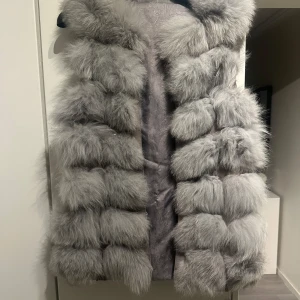 Grå pälsväst - Säljer en superfluffig och lyxig grå pälsväst. Den är perfekt för att hålla sig varm och stilren under kyliga dagar. Samt bra skick 