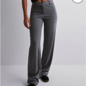 Low waist kostymbyxor - Säljer dessa fina lågmidjade gråa kostymbyxor från Nelly, de har endast använts ett par gånger så de är i perfekt skick. De har även sytts om för att bli kortare i benen så innerbenslängden är 70cm Originalpris: 499kr Skriv för frågor/prisförslag🫶