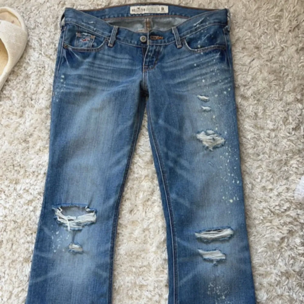 Supersnygga lågmidjade bootcut jeans med hål från hollister.   Midjemått rakt över - 39 Innerbenslängd - 74 Grenhöjd - 16cm. Jeans & Byxor.