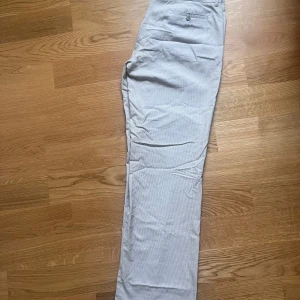 Kostumbyxa beige grårandig strl44 - Raka, vida byxor. Låg/normal midja 65%bomull, 33%polyester, 2%elastan