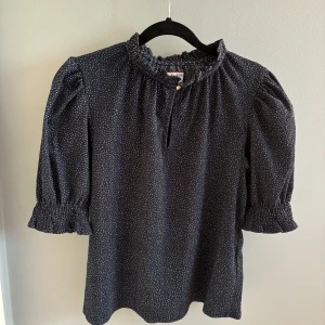 Mörkblå blus - En super söt mörkblå blus med liten puffärm och små vita prickar på, från Lindex💕Säljer på grund av att den inte längre kommer till användning. Inga defekter, nyskick!