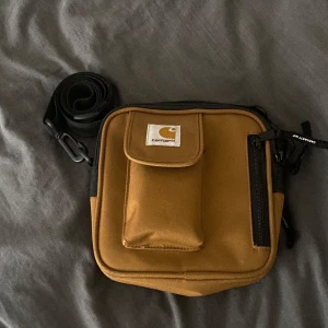 Carhartt essentialls bag small - Inga tecken på användning eller slitage, den är som ny. Originalpriset går på runt 700kr. Många bra fack.