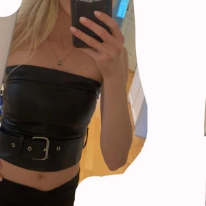Topp - Topp i läderimitation. Dragkedja i ryggen. Skärpet är avtagbart och man spänner åt det själv. Aldrig använd med prislapp kvar. Storlek XS. Vid frågor/fler bilder skriv! Prisförslag tas emot❤️