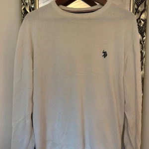 Grön tröja med dragkedja från Tommy Hilfiger - Säljer en snygg grön tröja från Tommy Hilfiger med dragkedja vid halsen. Perfekt för höst och vinter, den är både stilren och bekväm. Tröjan har en liten logga på bröstet och ribbade detaljer vid ärmslut och nederkant.