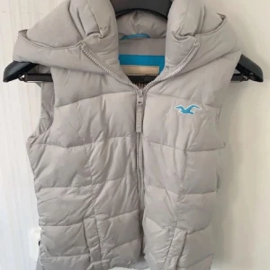 hollister väst - Vadderad hollister väst i storlek S, med luva och 2 fickor där fram