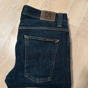 Nudie Jeans Grim Tim W30, L32 - Säljer nu dessa trendiga och snygga Nudie jeans. Mycket bra skick och känns som helt nya, inga defekter eller liknande. Storlek W30 L32. Nypris: 1,600kr. Säljer nu för 499. Kontakta vid minsta fundering. Pris går att diskutera.