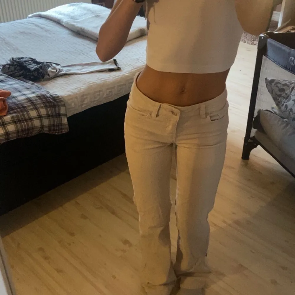 Säljer ett par snygga beige bootcut byxor. De är lågmidjade och har en tight passform upptill som övergår i en utsvängd stil vid benen. Perfekta för en avslappnad men ändå stilren look. Passar bra till både vardag och fest!. Jeans & Byxor.