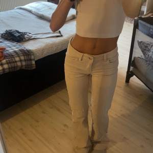 Säljer ett par snygga beige bootcut byxor. De är lågmidjade och har en tight passform upptill som övergår i en utsvängd stil vid benen. Perfekta för en avslappnad men ändå stilren look. Passar bra till både vardag och fest!