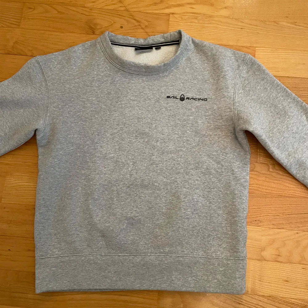 Säljer en grå sweatshirt från Sail Racing. Den är i helt nytt skick och aldrig andvänd.. Tröjor & Koftor.