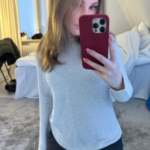 Beige stickad tröja - Säljer en stilren beige stickad tröja med långärmad design. Perfekt för kyligare dagar och enkel att matcha med olika outfits. Tröjan har en klassisk passform och är gjord i ett mjukt material.