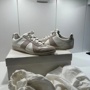 Maison Margiela Gat Skor - Säljer nu mina Maison margielas gat skor i den vita färgen, skorna är i otroligt bra skick bortsätt från att de är lite smutsiga, om du tvättar de blir de i princip som nya, kvitto och äkthetsbevis finns och de är storlek 44 men kan passa 43 med. Inga defekter eller skador och kommer med allt og! Skriv vid intresse!
