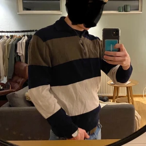 Brun/Blå/Vit Ziptröja från Massimo Dutti - Säljer en snygg randig tröja från Massimo Dutti i ull och kashmir. Tröjan har en dragkedja vid halsen och breda ränder i blått, brunt och vitt. Perfekt för en stilren look. Den är L men är tvättad i fel grader! Är precis för kort i armarna för mig, brukar ha S, så om ni letar för en tröja i Xs/S så är de perfekt!