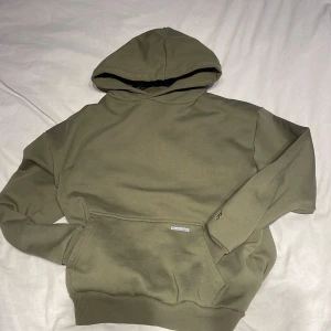Bazix Republiq hoodie - Säljer en olivgrön hoodie från Basic Republic. Den har en broderad bokstav 'B' på ärmen och en praktisk magficka. Perfekt för en avslappnad stil. Den är väldigt tung och najs kvalitet. Storlek xs men sitter oversized. Så kan passa mellan S-M beroende på hur man vill att den ska sitta. Endast andvänd 2 gånger. För mer frågor eller bilder är det bara att höra av dig!