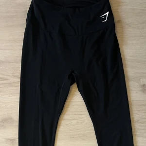 Svarta leggings från Gymshark, storlek S - Snygga och bekväma träningstights i svart. Hög midja för bra stöd och komfort. Perfekt för träningspass eller vardagsbruk. Tightsen har en diskret logotyp fram och bak. Storlek S och i bra skick!!