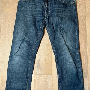 Blå jeansbyxor från Jacob Cohen - Snygga blå jeansbyxor från Jacob Cohän med klassisk femficksdesign och knappgylf. Perfekta för en avslappnad stil. Märkeslapp baktill och subtila slitningar ger en cool look. Kontakta vid några funderingar, pris kan diskuteras.