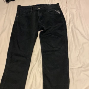 Svarta jeans från Replay - Snygga svarta jeans från Replay med klassisk femficksdesign och dragkedja. Perfekta för en stilren look. Märkesdetaljer synliga på baksidan och insidan av midjan. De är 30 32 men lappen är avklippt 