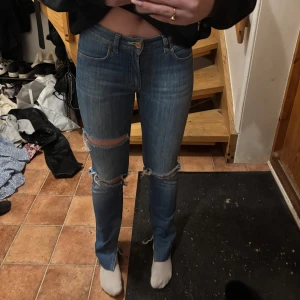 Jeans från acne  - Snygga blå jeans med slitningar på knäna. De har en klassisk femficksdesign och knappgylf. Perfekta för en avslappnad stil. De är lågmidjade och passar en som har storlek 36. Jag är 167 cm och de passar mig bra. De är från acne jeans 