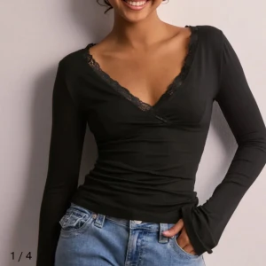 Svart långärmad topp med spetsdetaljer - Snygg svart långärmad topp med v-ringning och spetsdetaljer från Nelly, andvänd 1 gång❤️
