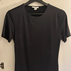 Svart bodysuit - Snygg svart bodysuit med korta ärmar och rund hals. Säljer min svarta bodysuit från new yorker då den inte kommer till användning, endast använd en gång och är i storleken L