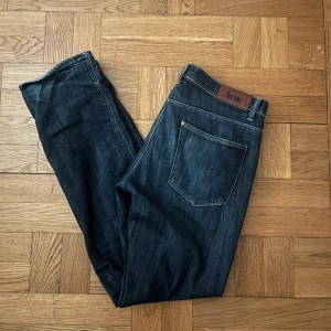 Mörkblå jeans från Acne - Snygga mörkblå jeans från Acne med klassisk femficksdesign. Tillverkade i bomull med en liten del elastan för extra komfort. Perfekta för en stilren look. Nypris ca 2000kr