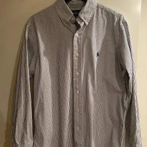 Randig skjorta från Ralph Lauren - Säljer min skjorta från Ralph lauren i storlek L då den inte kommer till användning. Skjortan är inte använd många gånger och är ett perfekt alternativ på en skjorta till sommaren. Bara att höra av sig vid frågor och funderingar!