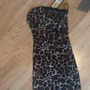 Leopardmönstrad klänning - Snygg leopardmönstrad klänning med en tight passform. Klänningen är axelbandslös och har en elegant design som passar perfekt för en utekväll. Helt ny, prislapp är kvar🩷