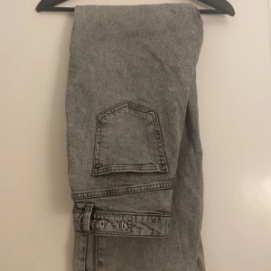 Grå jeans från NA-KD - Snygga grå jeans från NA-KD med en cool tvättad look. De har en klassisk femficksdesign och en bekväm passform. Perfekta för en avslappnad stil.