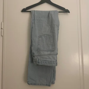 Ljusblå jeans från NA-KD - Snygga ljusblå jeans från NA-KD med en klassisk design. De har en rak passform och är tillverkade i jeansmaterial. Perfekta för en avslappnad stil. Har en liten fläck på ena byxbenet (se bild 3)