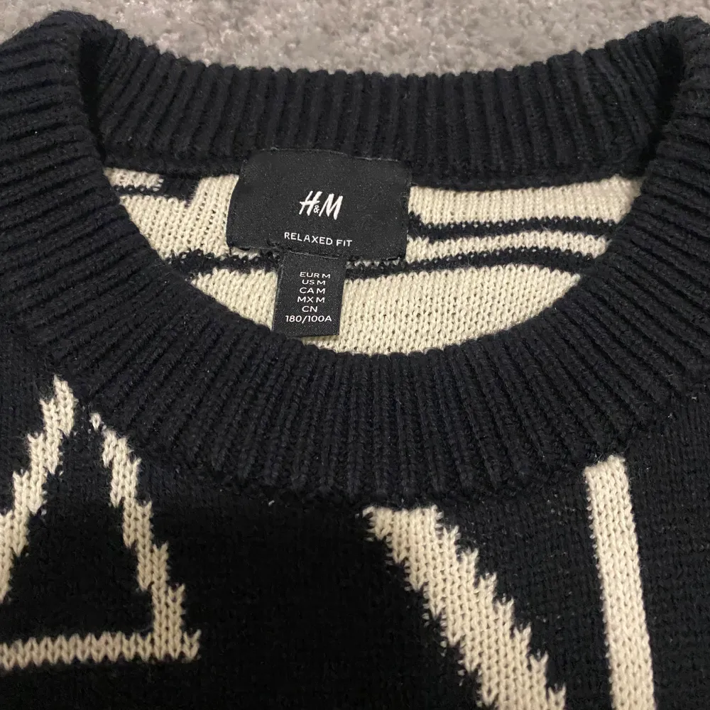 Säljer en svart tröja från H&M med stora vita bokstäver som bildar ordet 'PAUSE'. Tröjan har en avslappnad passform och långa ärmar. Perfekt för en cool och avslappnad stil. Kan kännas lite som oversize!. Neuletakit & Villapaidat.