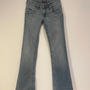 Blå bootcut jeans - Snygga blå bootcut jeans med klassisk femficksdesign och dragkedja. Perfekta för en avslappnad stil. De har en normal passform och är tillverkade i jeansmaterial.   34,81cm