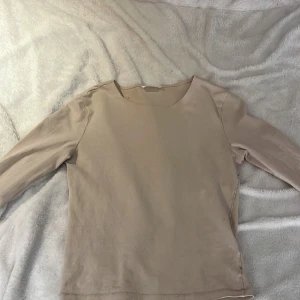Beige långärmad topp från Gina Tricot - Säljer en beige långärmad topp från Gina tricot. Nästan oanvänd. Storlek XS.