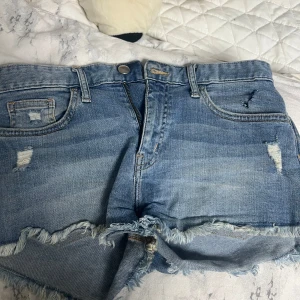 Blå jeansshorts med slitningar - Snygga blå jeansshorts med slitna detaljer. 