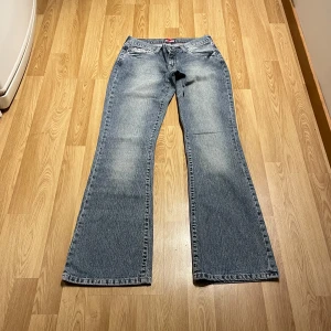 Lågmidjade bootcut jeans - (12) Ljusblåa lågmidjade bootcut jeans i en otrolig blå/grå stentvätt, och unika fickor. Midjemått rakt över: 36, innerbenslängd: 81💓