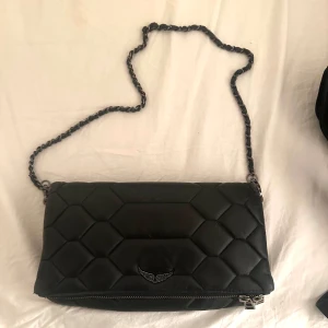 Svart Zadig väska - Snygg svart axelväska från Zadig & Voltaire i använt skick, därav lite slitningar o missfärgad kedja men annars inga störrre defekter!