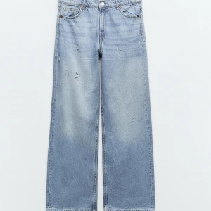 zara blå straight jeans med slitningar - Snygga blå jeansbyxor med en avslappnad wide fit och coola slitningar. Perfekta för en trendig look. Klassisk femficksdesign och knappgylf.