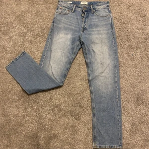 Jack & Jones jeans - Ett par snygga ljusblåa Jack & Jones jeans för ett bra pris! De har en mörk blå stil med ljus fade vid låren. Storleken är W28/L32 och är i relaxed fit. PRIS KAN DISKUTERAS!