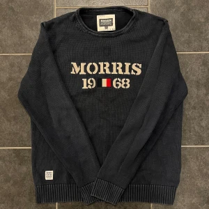 Svart tröja från Morris - Snygg svart tröja från Morris med texten 'Morris 1968' på framsidan. Tillverkad i 100% bomull, vilket gör den både bekväm och hållbar. Perfekt för en stilren look.