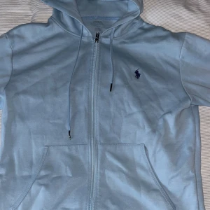 Ljusblå hoodie från Polo Ralph Lauren - Säljer en ljusblå zip up hoodie från Polo Ralph Lauren 