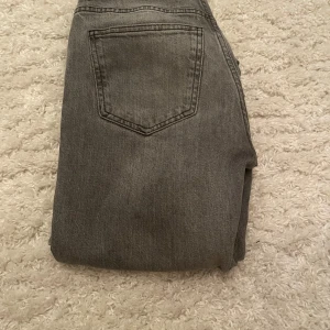 Grå jeans från Ginatricot ”flare” - Snygga grå jeans från Ginatricot  med klassisk femficksdesign och knappgylf. Perfekta för en avslappnad stil. De har en rak/flare passform. Innerbenslängd 82 cm🩷 Köpare står för frakten!
