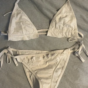 Vit bikini från ASOS - Snygg vit bikini från ASOS med broderade detaljer. Toppen har knytband och trekantsform, medan trosorna har knytband i sidorna. Storlek xs, aldrig använd !