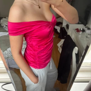Rosa offshoulder topp - Snygg rosa offshoulder topp med knytdetalj framtill. Perfekt för en somrig look med sin figurnära passform och glansiga finish💕💕