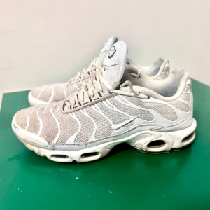 Nike sneakers i beige och vit - Snygga Nike sneakers i beige och vit med ett unikt vågigt mönster. Skorna har en bekväm passform och är perfekta för vardagsbruk. De har en synlig luftdämpning i sulan för extra komfort.