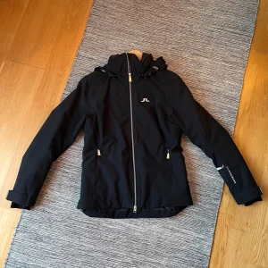 Fodrad skidjacka från J.Lindeberg - Svart fodrad skidjacka i storlek S från J.Lindeberg. Varsamt använd. Som ny.    Nypris 5 500kr  Säljes för 2 700kr